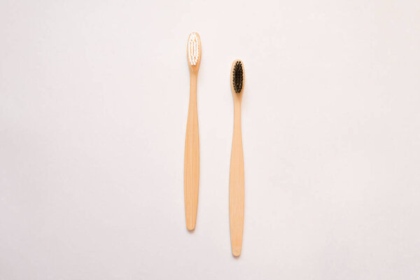 Bamboo toothbrushes with white and black bristles on white. Eco friendly toothbrush concept. copy space for text