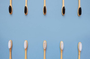 Mavi üzerine bambu diş fırçası. Ağzın için sıfır atık, çevre dostu diş bakımı. Çevre dostu güvenli diş fırçası konsepti. Düz konum, üst görünüm, kopyalama alanı.