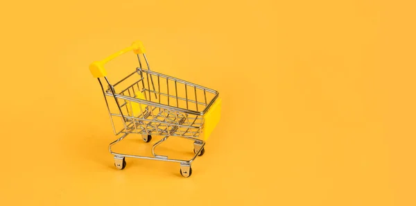 Empty shopping trolley on a bright yellow background. Shopping, online shopping concept, black friday, sale, discounts, fast delivery, online shopping. copy space for text, banner. mockup