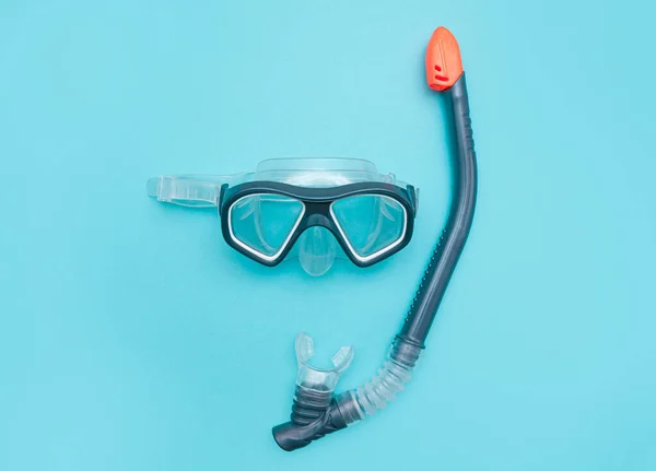 Diving mask with snorkel on a turquoise blue background. minimalistic photo of a mask and snorkel for swimming in a pool or sea with a central composition.Concept of summer tropical seaside recreation