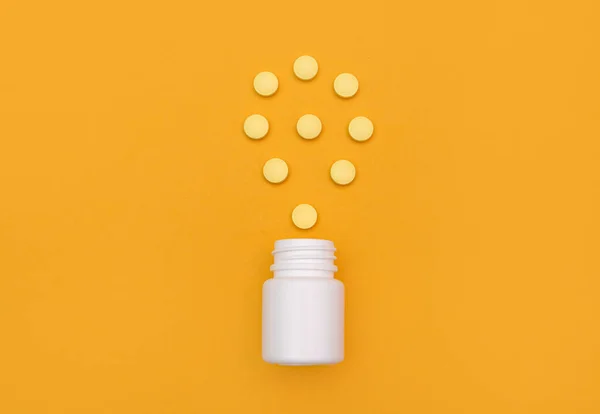 Cápsulas Dos Comprimidos São Dispersadas Frasco Branco Sobre Fundo Amarelo — Fotografia de Stock