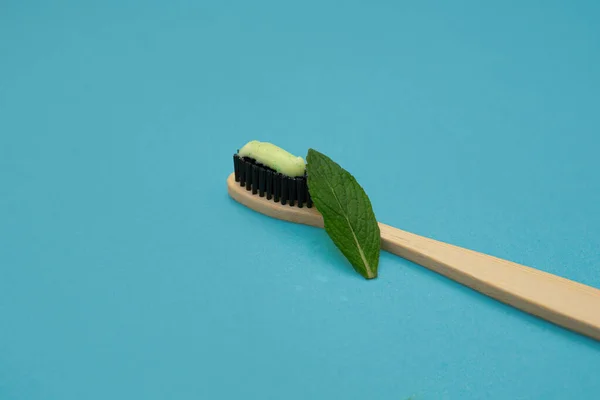 Wooden Bamboo Toothbrush Toothpaste Next Green Mint Leaf Blue Background — Stock Photo, Image