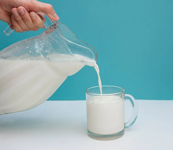 Hand Gießt Milch Ein Glas Mit Einem Spritzer Und Nahaufnahme — Stockfoto