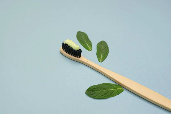 Bamboo Toothbrush Toothpaste Several Green Mint Leaves Blue Background Concept — Stock Photo, Image