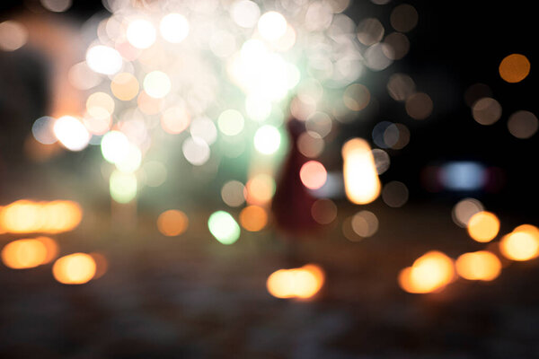 Abstract background of blurry bokeh lights, different colors, orange, yellow, bright colored fireworks or salute. selective focus