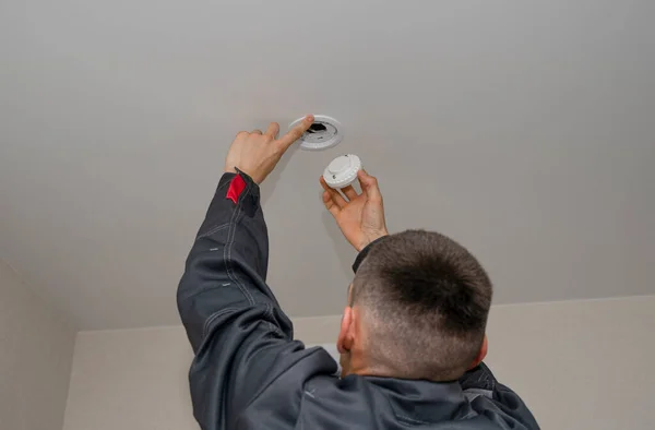 Bir elektrikçi gergin bir tavana spot ışığı yerleştirir ya da değiştirir. Bir elektrikçi tavana modern LED lambalar takıyor. Enerji tasarrufu teknolojisi kavramı. Bir elektrikçi çalışıyor..