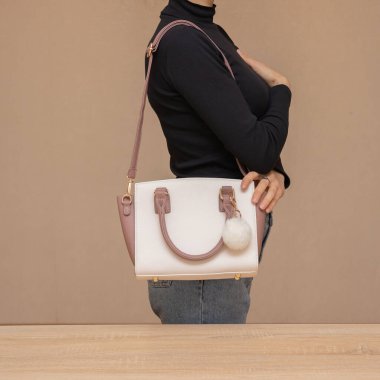 Bir kız bir çanta kadar işlevseldir. Kız beyaz çantayı sunar.