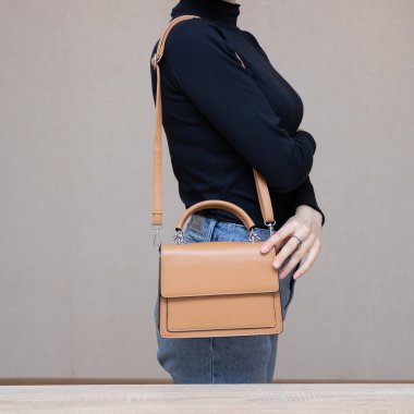 Bir kız bir çanta kadar işlevseldir. Kız çantayı sunar.