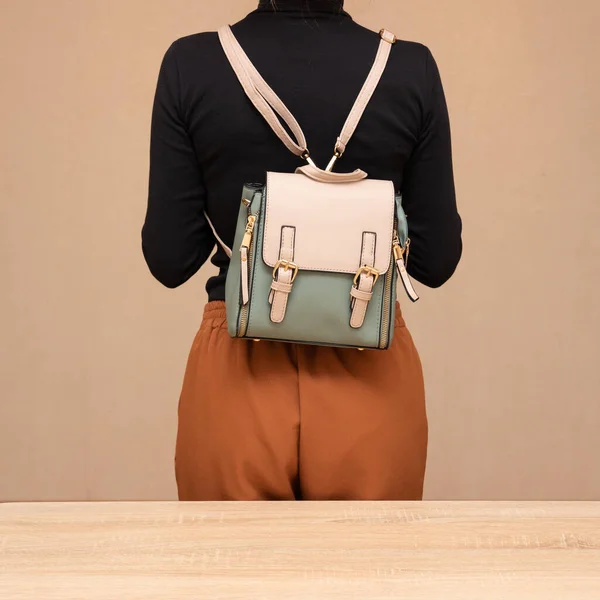 Bir kız bir çanta kadar işlevseldir. Kız çantayı sunar.