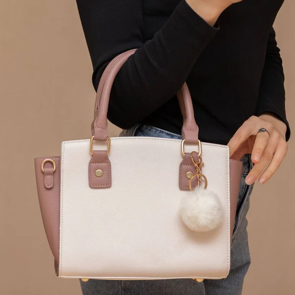 Bir kız bir çanta kadar işlevseldir. Kız beyaz çantayı sunar.