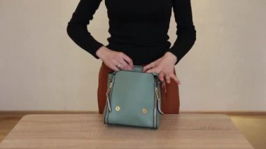 Bir kız bir çanta kadar işlevseldir. Kız çantayı sunar.