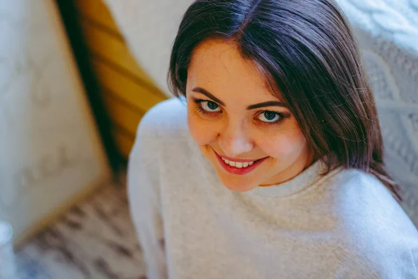 Yakından bir kızın portresi, kız gülümseyip objektife bakıyor.