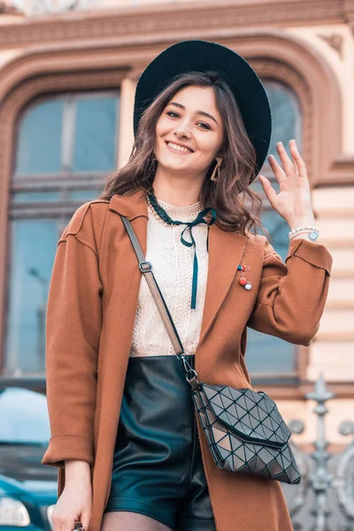 Şehirdeki kız. Sonbahar giysileri. Şapkalı kız. Kız şapkayla gülümsüyor