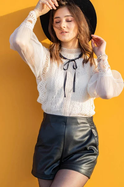 Sarı arka planda şapkalı kız. Sarı arka planda bir kız