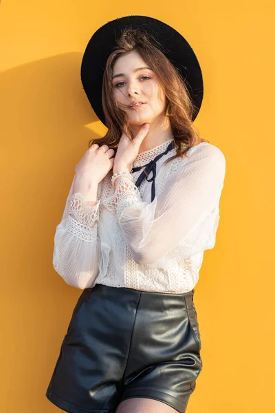 Sarı arka planda şapkalı kız. Sarı arka planda bir kız