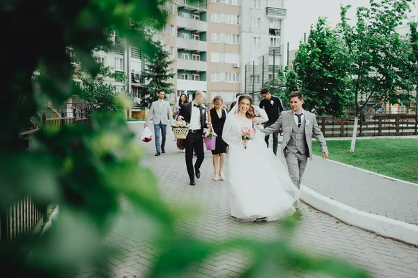 花嫁と新郎と若者が歩く — ストック写真