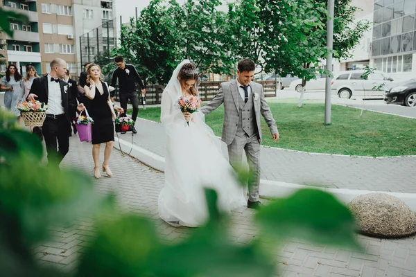 花嫁と新郎と若者が歩く — ストック写真
