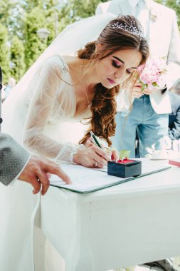 Gelin evlilik belgesini imzalar.