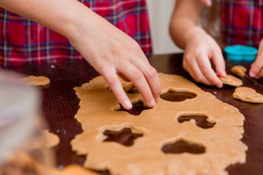 İki küçük kız Noel için mutfakta zencefilli kurabiye pişiriyor.