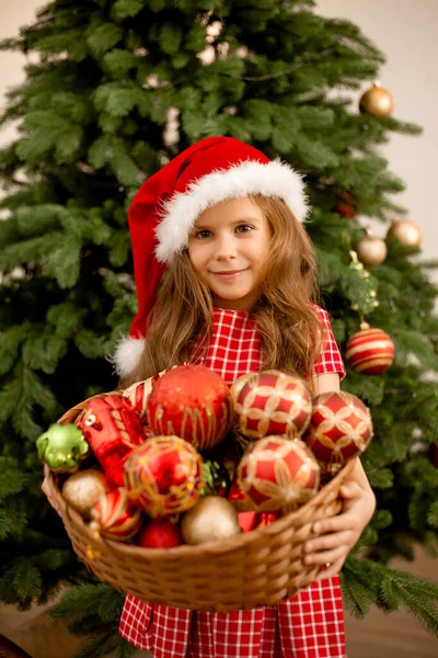 Χαριτωμένο Κοριτσάκι Ένα Καπέλο Santa Κρατώντας Ένα Καλάθι Παιχνίδια Στο — Φωτογραφία Αρχείου