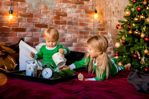 Δύο Παιδιά Πιτζάμες Τρώνε Πρωινό Στο Κρεβάτι Δίπλα Στο Χριστουγεννιάτικο — Φωτογραφία Αρχείου