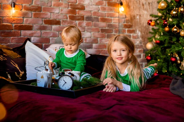 Dos Niños Pijama Desayunando Cama Junto Árbol Navidad —  Fotos de Stock