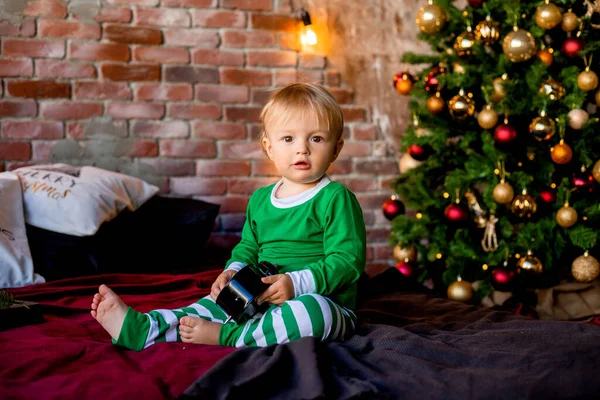 Χαριτωμένο Νήπιο Πιτζάμες Στο Κρεβάτι Πρωί Δίπλα Στο Χριστουγεννιάτικο Δέντρο — Φωτογραφία Αρχείου