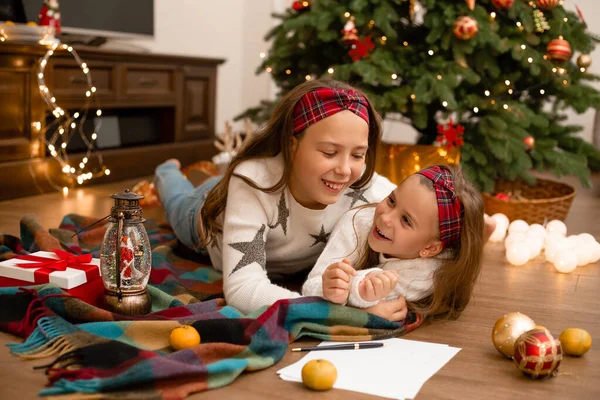 Duas Meninas Chão Madeira Casa Lado Árvore Natal Escrevendo Uma — Fotografia de Stock