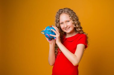 Stüdyoda kumbarası olan genç sarışın kız. 