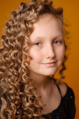 Stüdyoda kahverengi arka planda güzel sarışın genç bir kız var. 