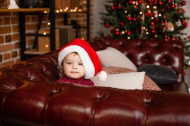 Sevimli Noel Baba evde Noel ağacının yanında hediyelerle oturuyor.