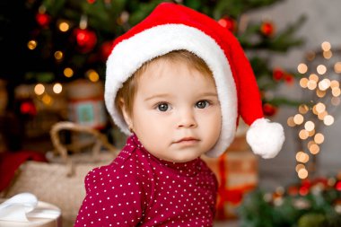 Sevimli Noel Baba evde Noel ağacının yanında hediyelerle oturuyor.