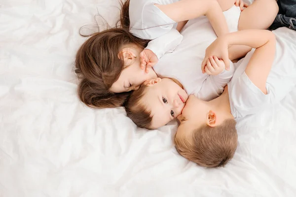 Τρία Μικρά Παιδιά Ξαπλώνουν Στο Κρεβάτι Και Αγκαλιάζονται Θέα Από — Φωτογραφία Αρχείου