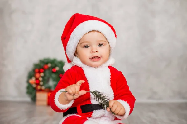 Söta Baby Santa Sitter Ett Trägolv Med Gåva Och Julkrans — Stockfoto