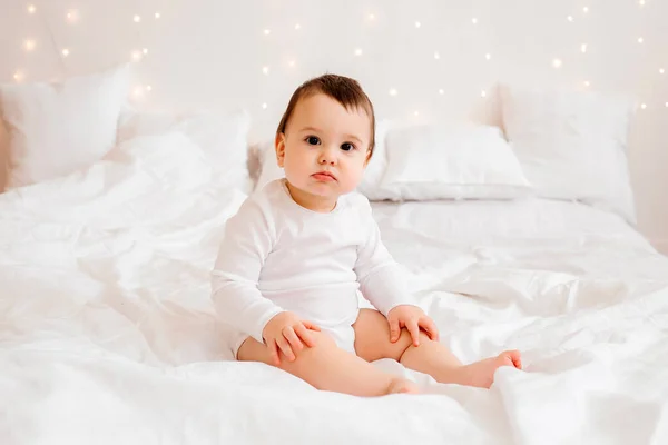 Zdrowy Chłopiec Miesięcy Białych Ubraniach Uśmiechnięty Siedzi Białej Pościeli Łóżku — Zdjęcie stockowe