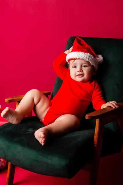 Bonito Bebê Papai Noel Senta Uma Cadeira Entre Presentes Natal — Fotografia de Stock