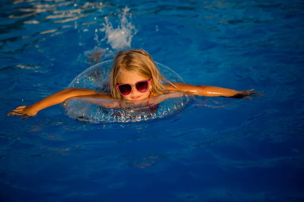 Маленькая Девочка Солнцезащитных Очках Плавает Бассейне Кругом — стоковое фото