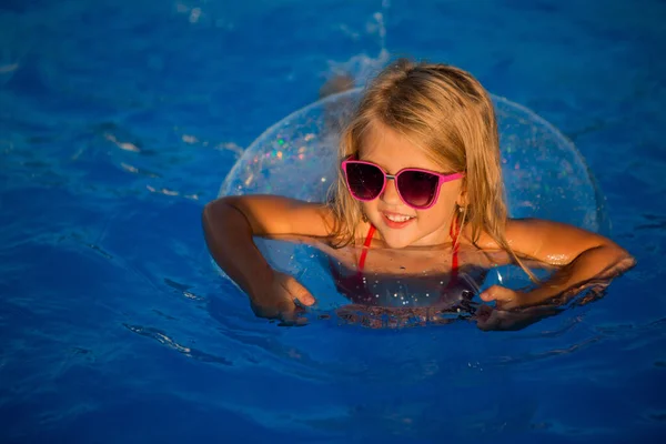 Улыбающаяся Маленькая Девочка Солнечных Очках Плавающая Бассейне Кругом — стоковое фото