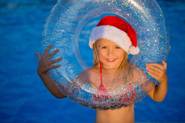 Улыбающаяся Маленькая Девочка Рождественской Шляпе Держащая Кружок Бассейна — стоковое фото