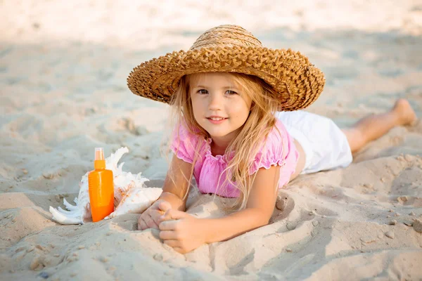 Улыбающаяся Маленькая Девочка Соломенной Шляпе Позирующая Песке Раковиной Спрей Бутылкой — стоковое фото