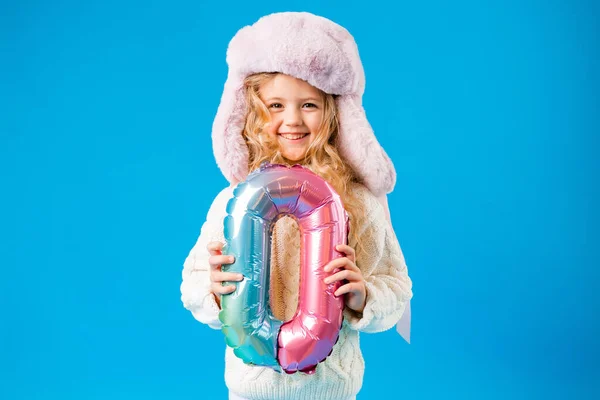Kışlık Elbiseli Küçük Kız Gülümser Mavi Arka Planda Sıfır Numaralı — Stok fotoğraf