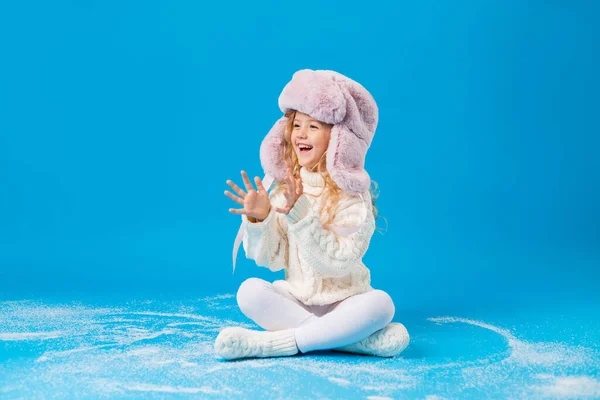 Mavi Sırtında Sahte Karla Kışın Giyinmiş Mutlu Küçük Kız — Stok fotoğraf