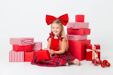 Şirin küçük kız stüdyo zemininde oturmuş hediyelerle