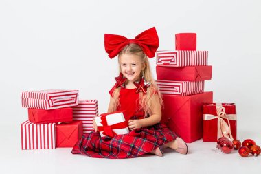 Şirin küçük kız stüdyo zemininde oturmuş hediyelerle