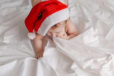 Noel Baba şapkalı bebek yatakta yatıyordu.