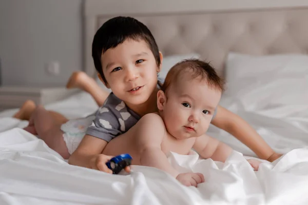 Duas Crianças Abraçando Cama Olhando Para Câmera — Fotografia de Stock