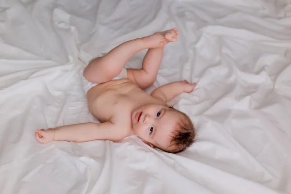 Bambino Sdraiato Lenzuola Bianche Con Piedi — Foto Stock