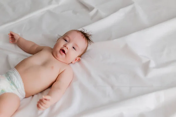 Χαριτωμένο Μωρό Ξαπλωμένο Στο Κρεβάτι Λευκά Σεντόνια — Φωτογραφία Αρχείου