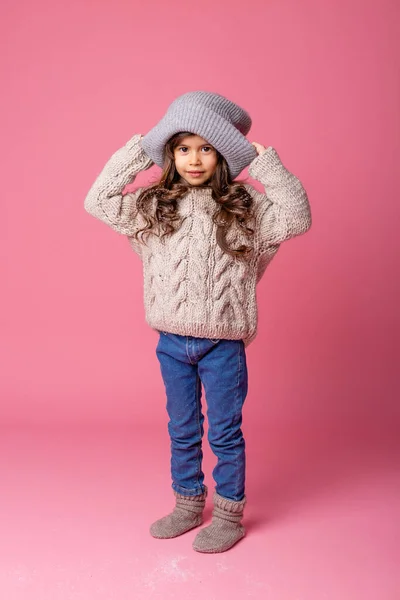 Pembe Arka Planda Duran Kalın Giysiler Giyen Küçük Kız — Stok fotoğraf