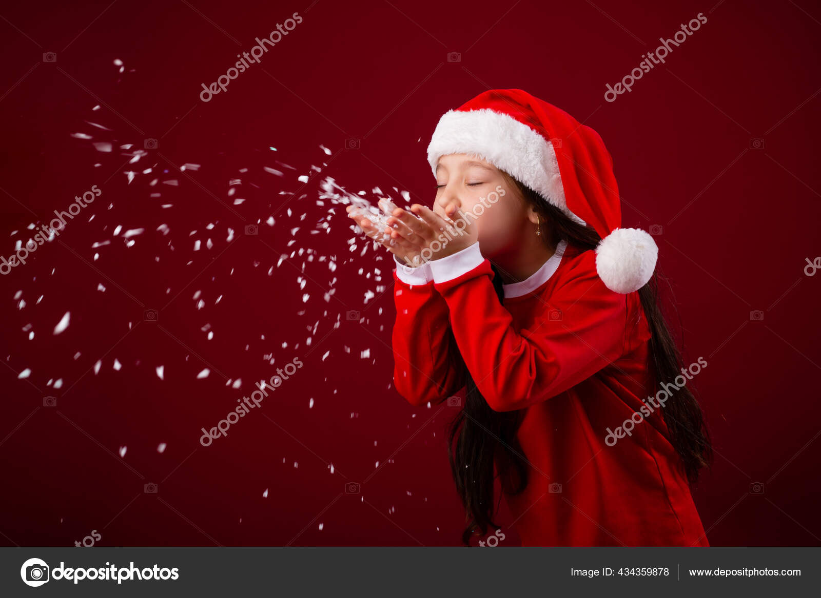 穿着桑塔服装的可爱小女孩在红色背景上吹雪 图库照片 C Krisfotostav 穿着桑塔服装的可爱小女孩在红色背景上吹雪 图库照片 C Krisfotostav